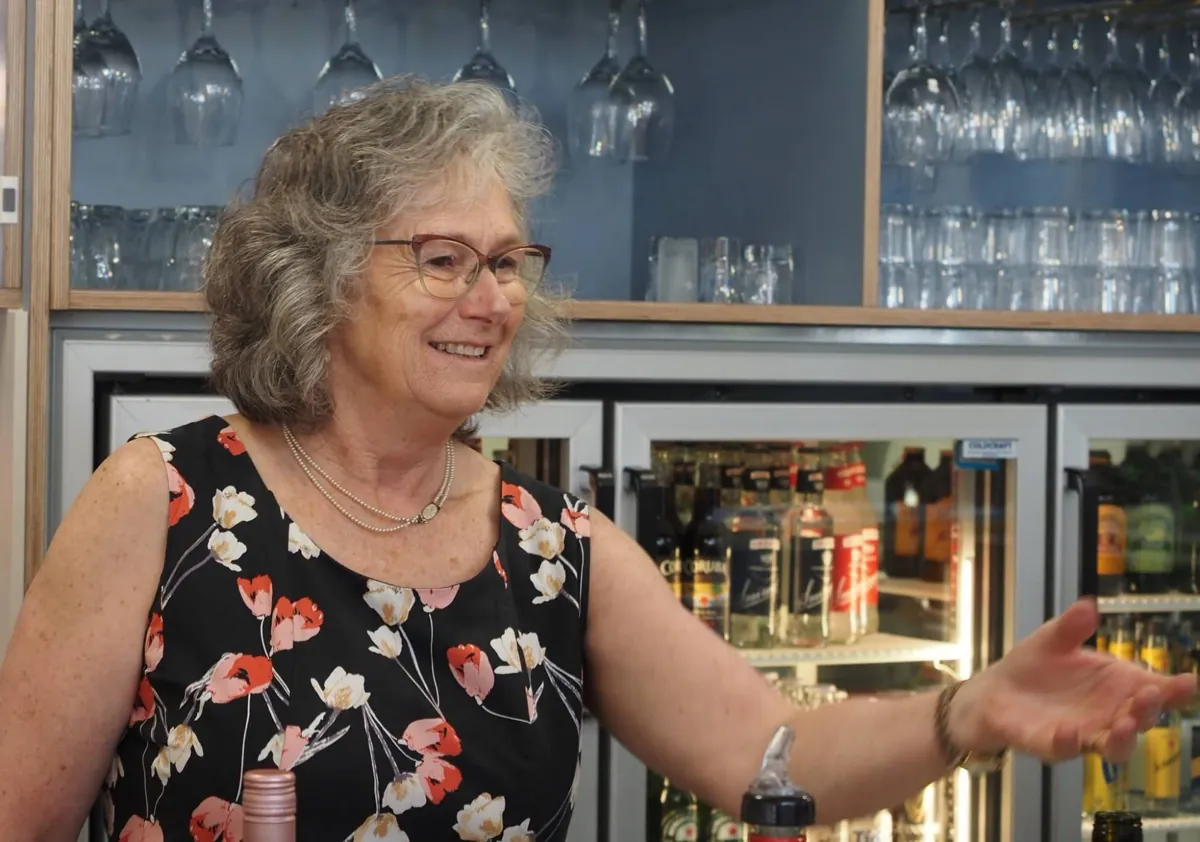 A smiling member behind the bar in the refurbished clubhouse